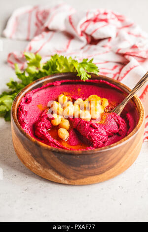 Zuckerrüben hummus in eine hölzerne Schüssel mit Gemüse. Auf Basis pflanzlicher Ernährung Konzept. Stockfoto