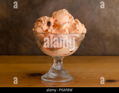Rum und Rosinen icecream in Glasschale auf rustikalen Holztisch Stockfoto