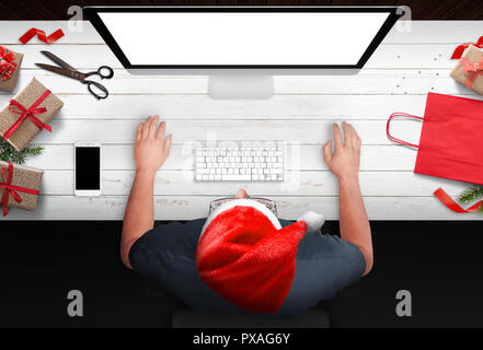 Christmas shopping aus dem Sessel. Mann Geschenke online kaufen bei Ermäßigungen. Beutel, Streifen und Geschenke neben. Isolierte Computer Display für mockup. Stockfoto