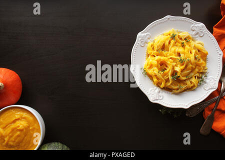 Tagliatelle mit Kürbis Sauce über schwarzen Hintergrund. Top View Stockfoto