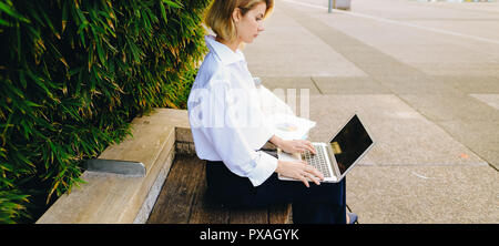 Nahaufnahme, Gesicht und Hände von Frau Eingabe durch Laptop Tastatur im Freien. Konzept der maschinenschreiben Fähigkeiten und Geschäftsfrau. Junge weibliche Person working Outs Stockfoto