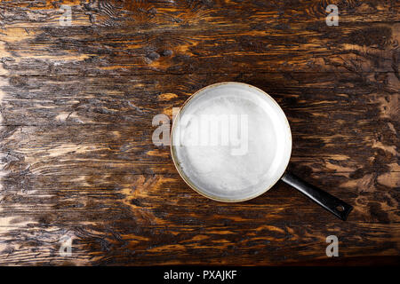 Alte Aluminium Pfanne auf einem hölzernen Hintergrund. Platz für Text Stockfoto