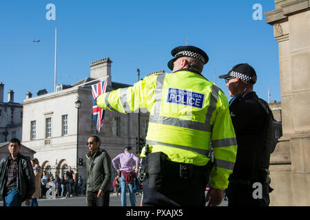 Ein Metropolitan-Polizist zeigt mit dem Finger auf jemanden in der Menge während einer Demo in Whitehall, Westminster, London, England, Großbritannien Stockfoto