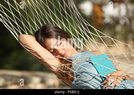 Gerne entspannt Frau schlafen auf einer Hängematte mit einer Tablette auf Ferienhäuser Stockfoto