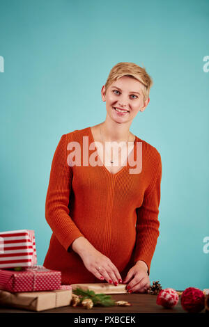 Professionelle Designer hält Geschenk und Verpackung Papier in der Hand. Stockfoto