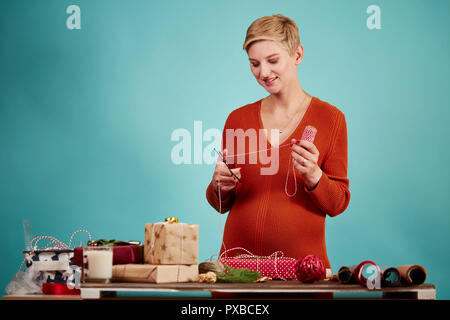 Professionelle Designer hält Geschenk und Verpackung Papier in der Hand. Stockfoto