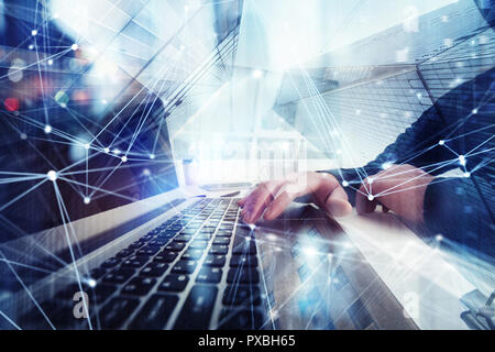 Business Mann arbeitet im Büro mit Laptops im Vordergrund. Konzept der Teamarbeit und Partnerschaft. Double Exposure mit Netzwerkeffekten Stockfoto