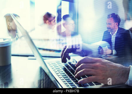 Business Mann arbeitet im Büro mit Laptops im Vordergrund. Konzept der Teamarbeit und Partnerschaft. Double Exposure Stockfoto