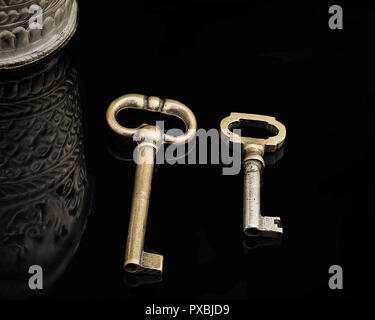 Bronze Vintage Keys. Zwei alte kleine bronze Tasten auf einem schwarzen Hintergrund. Stock Bild. Stockfoto