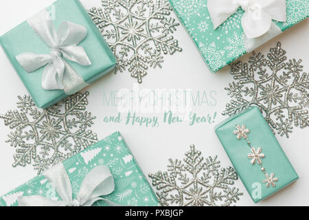 Schöne Weihnachtsgeschenke und Silber Schneeflocken auf weißem Hintergrund. Türkisfarbenen gewickelt Xmas-Boxen. Geschenkverpackung Konzept. Stockfoto