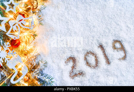 Weihnachten Tannenbaum mit Lichtern auf verschneiten Hintergrund. Frohe Weihnachten und guten Rutsch ins Neue Jahr!! Ansicht von oben. Stockfoto