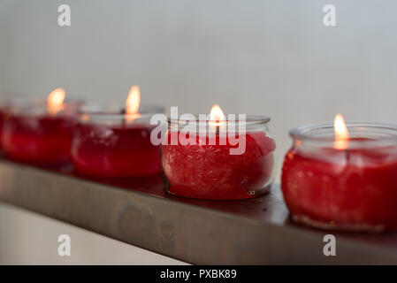 Vier rote Kerzen im Glas Tassen in der Zeile in einem buddhistischen Tempel, Chengdu, China Stockfoto