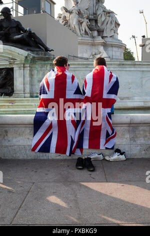 Zwei junge Männer in Union Jack Fahnen eingewickelt und kühlen ihre Füße im Brunnen vor dem Buckingham Palace. Stockfoto