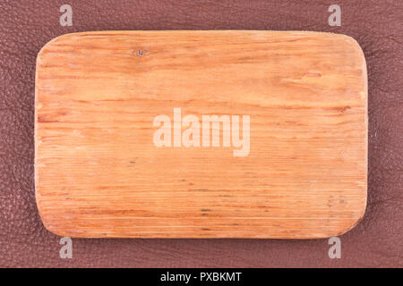 Rahmen aus Plank liegt auf Dunkelbraunem Naturleder. Textur eines Baumes. Blick von oben. Stockfoto