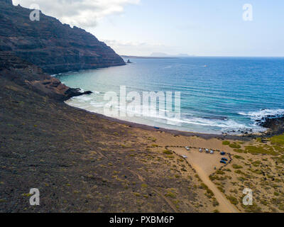 Luftaufnahme von einem kristallklaren Meer mit Wellen und Surfer. Playa De La Canteria. Orzola, Lanzarote, Kanarische Inseln. Spanien Stockfoto