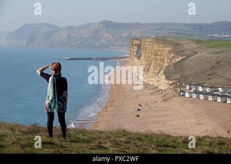 Dorset, Großbritannien. Okt 2018 21. Die Menschen genießen das warme Wetter im Osten Klippen gesehen von Burton Bradstock schauen nach Westen Bay in Dorset Credit: Finnbarr Webster/Alamy leben Nachrichten Stockfoto