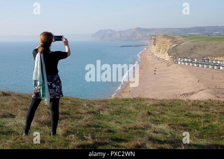 Dorset, Großbritannien. Okt 2018 21. Die Menschen genießen das warme Wetter im Osten Klippen gesehen von Burton Bradstock schauen nach Westen Bay in Dorset Credit: Finnbarr Webster/Alamy leben Nachrichten Stockfoto