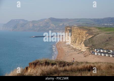 Dorset, Großbritannien. Okt 2018 21. Die Menschen genießen das warme Wetter im Osten Klippen gesehen von Burton Bradstock schauen nach Westen Bay in Dorset Credit: Finnbarr Webster/Alamy leben Nachrichten Stockfoto