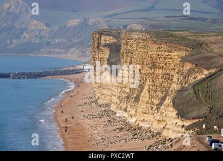 Dorset, Großbritannien. Okt 2018 21. Die Menschen genießen das warme Wetter im Osten Klippen gesehen von Burton Bradstock schauen nach Westen Bay in Dorset Credit: Finnbarr Webster/Alamy leben Nachrichten Stockfoto