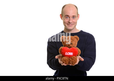 Gerne kahl kaukasischen Mann lächelnd und Teddybär mit hören Stockfoto