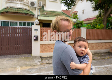 Vater und Sohn kleben zusammen zu Hause im Freien Stockfoto