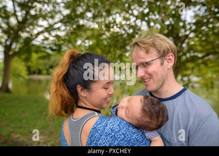 Multi-ethnischen junge Familie kleben zusammen im Park Stockfoto