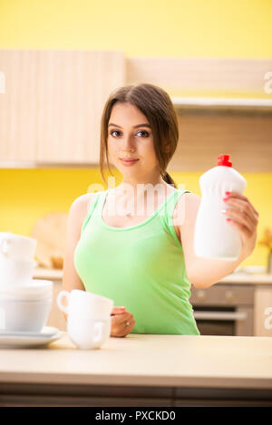 Junge Frau Reinigung und Abwasch in der Küche Stockfoto