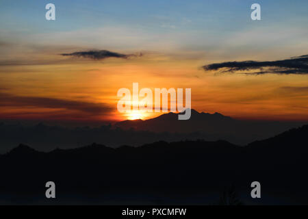 Frühen sonnenaufgang Blick von Gunung Batur Vulkan auf Bali, Indonesien mit sichtbaren Silhouette des Rinjani Berge Stockfoto