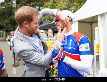 Der Herzog von Sussex hilft auf eine französische Radfahrer Helm zu setzen, wie er trifft, die Wettbewerber, die an die 2018 Invictus Spiele in Sydney, Australien. Stockfoto