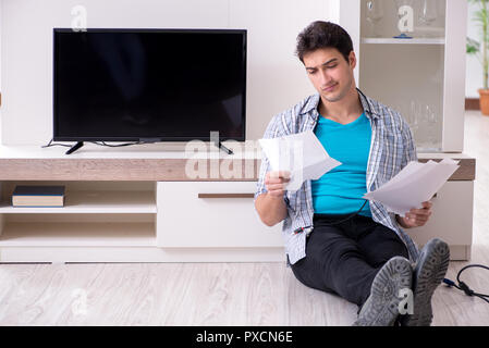 Mann, der versucht, defekte Fernseher zu reparieren Stockfoto