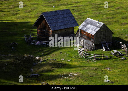 Holzhütten auf eine Almwiese im Herbst, Slowenien, Stockfoto