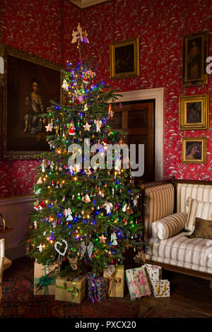 Das VEREINIGTE KÖNIGREICH, England, Yorkshire, Castle Howard an Weihnachten, Ankleidezimmer, verpackte Geschenke unter traditionell eingerichtete Xmas Tree Stockfoto