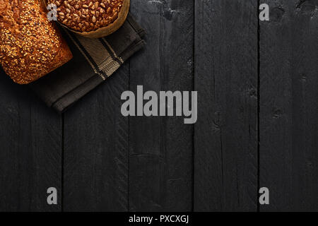 Verschiedene knuspriges Vollkornbrot auf schwarzer Holztisch. Ansicht von oben mit der Kopie Platz für Text, Menü oder Rezepte. Stockfoto