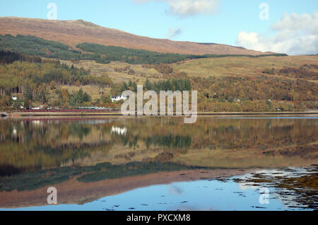 Rauch, spiegelt sich in Loch Eil aus der (jacobite Herr der Inseln) Dampflok auf dem Weg zur schottischen Berge Corbett Stob Coire ein 'Chearcaill Stockfoto