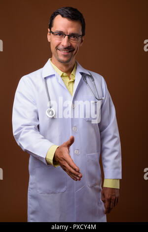 Portrait von stattlicher Mann Arzt mit Handschlag und Lächeln. Stockfoto