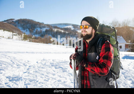 Mann mit Skiern und Rucksack auf dem Berg Stockfoto