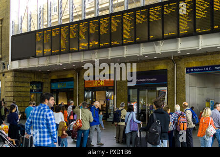 Pendler, der an der Zentrale elektronische Zug Aushänge in der halle des Bahnhof King's Cross, London, UK Stockfoto