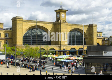 King's Cross Station Fassade mit Plaza und Marktstände sowie pendler vorbei gehen., London, UK Stockfoto