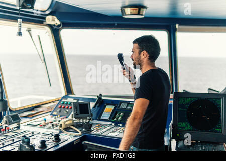 Marine nautischer Offizier ist Berichterstattung von UKW-Radio Stockfoto