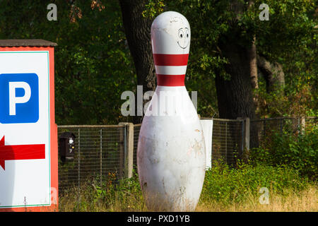 Bowling Kegel mit weissen und roten Streifen vor grünem Hintergrund Stockfoto