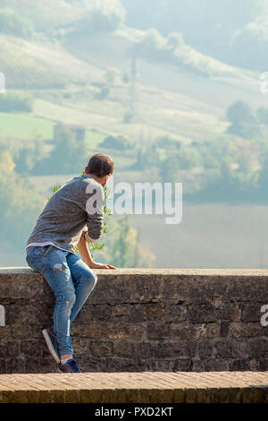 Rückansicht eines touristischen Mann sitzend beobachten, das Panorama, Castell'Arquato, Piacenza, Italien Stockfoto