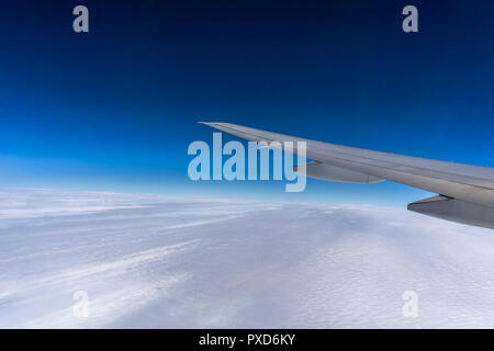Fliegen über den Wolken. Flugzeugflügel mit blauem Himmel und Kopieren. Reise und Verkehr Konzept. Stockfoto