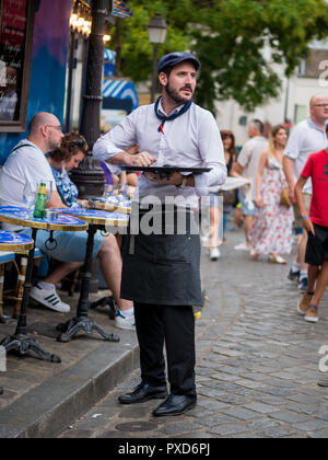 Paris, Frankreich, 12. August 2018: ein Kellner Kunden auf traditionelle im Pariser Café, das in Montmartre. Stockfoto