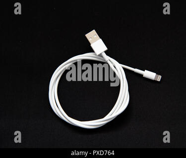 Eine weiße USB-Kabel mit einem Apple Lightning Connector isoliert auf Schwarz. Stockfoto