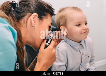 Lächelnd little boy in Ohr Untersuchung mit otoskop Stockfoto