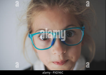 Closeup Portrait von schönen erstaunt angesichts der kleinen kaukasischen Girl in Gläsern Stockfoto