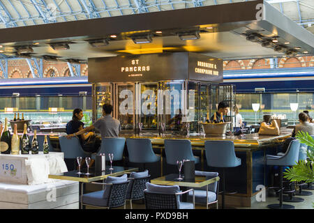 ST Pancras Searcys Brasserie und Champagne Bar mit Leuten saßen an der Bar und Eurostar-Zug im Hintergrund, London, Großbritannien Stockfoto