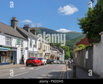 Straße im VIALLAGE von rostrevor County Down an einem sonnigen Sommertag mit Kilbroney Forest Park im Hintergrund. Stockfoto