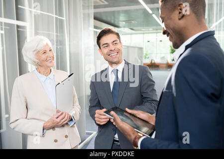 Freundliche Geschäftspartner Lachen, während sie im Büro Stockfoto