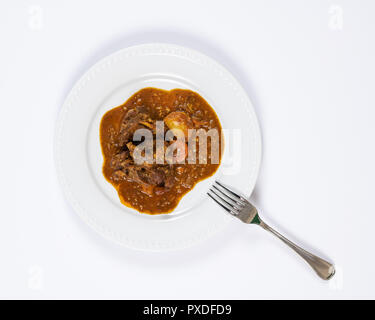 Close-up Platte von bunten Ziege Eintopf mit Kartoffeln, Karotten, Zwiebeln, Lorbeerblatt, und andere Gewürze. Stockfoto